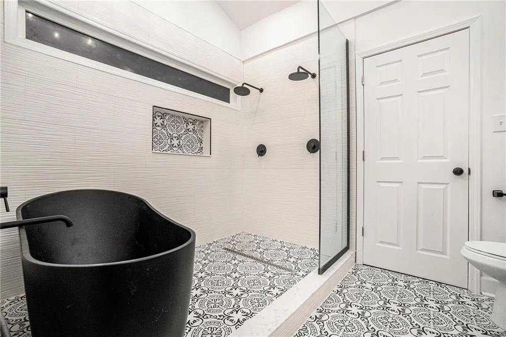 Bathroom featuring a shower stall and a freestanding tub
