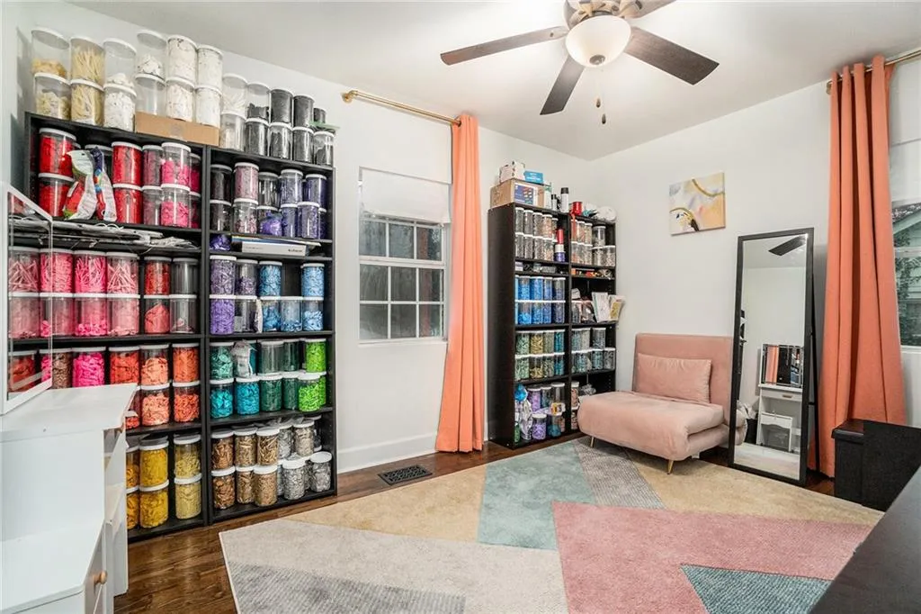 Living area featuring dark wood-style floors and a ceiling fan
