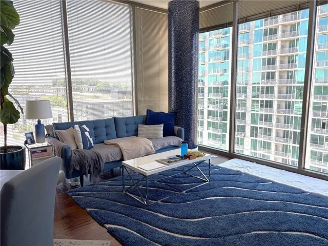 Floor-to-ceiling windows with horizontal blinds provide abundant natural light