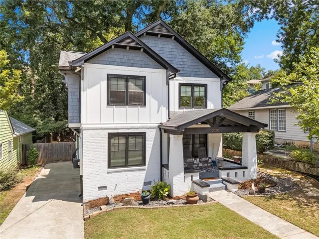 Two-story residence featuring a white brick and horizontal siding exterior with dark trim accents