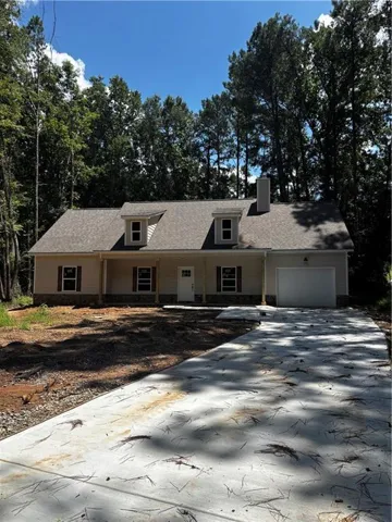 Contemporary single-story residence with a light-colored facade, dark shingle roof, and a stone foundation accent