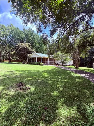 Expansive lawn with mature trees and a screened-in porch