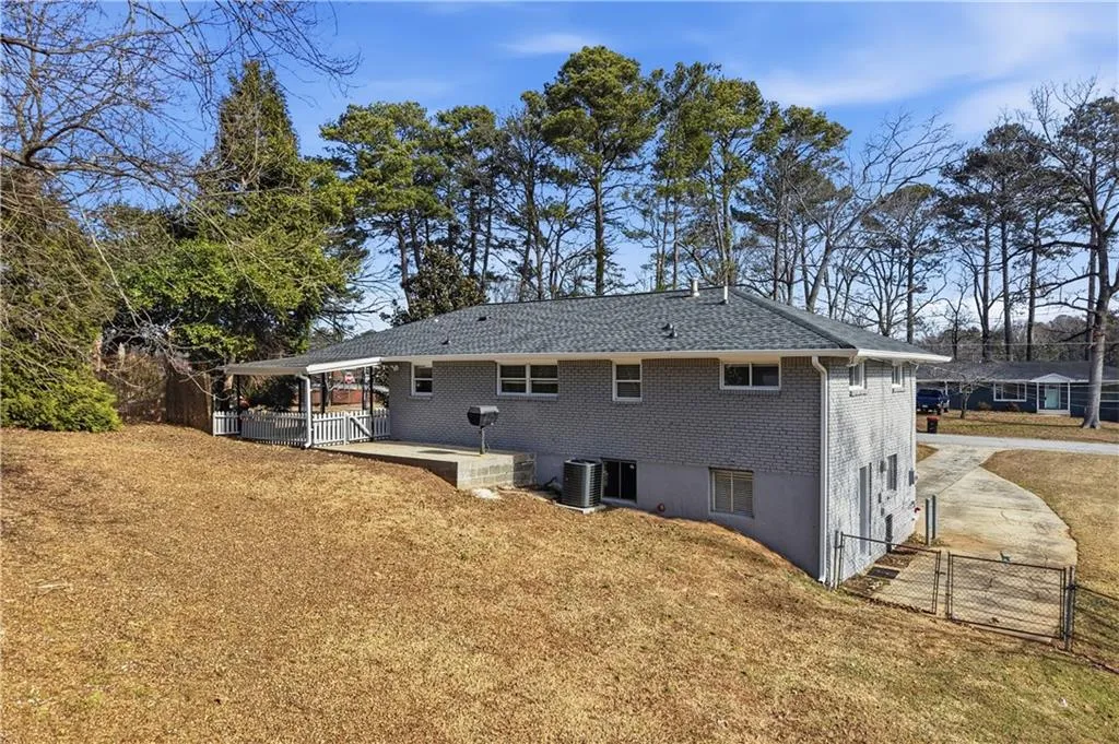 Back of house featuring a gate and brick siding