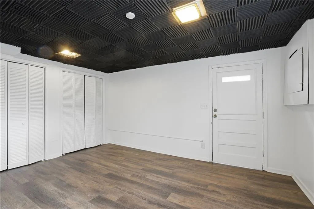 large room with closet and laminate flooring   exterior entry