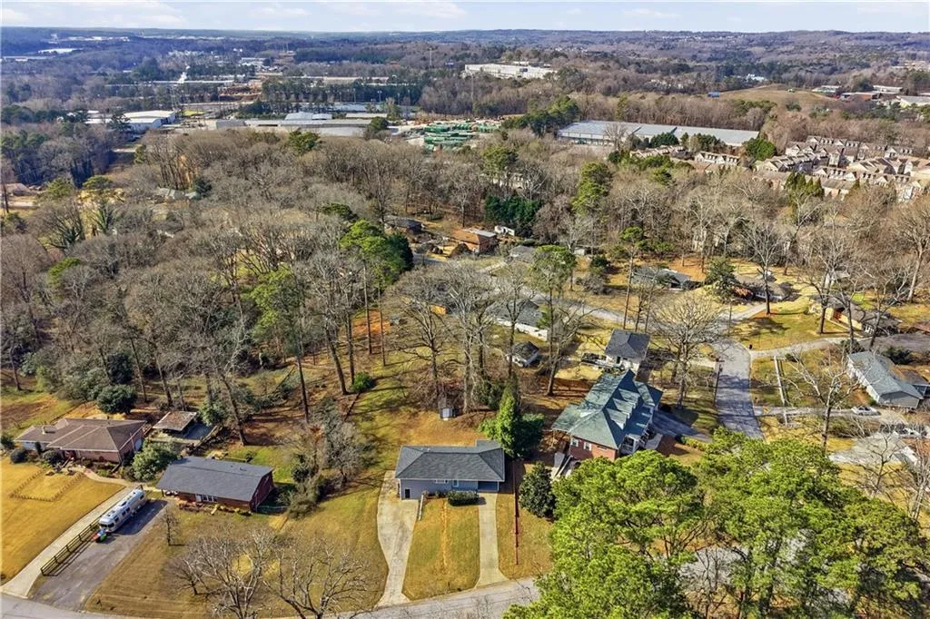 Aerial view of property and surrounding area with nearby suburban area