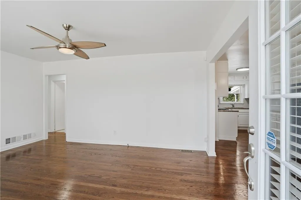 Unfurnished room with dark wood-style floors and a ceiling fan