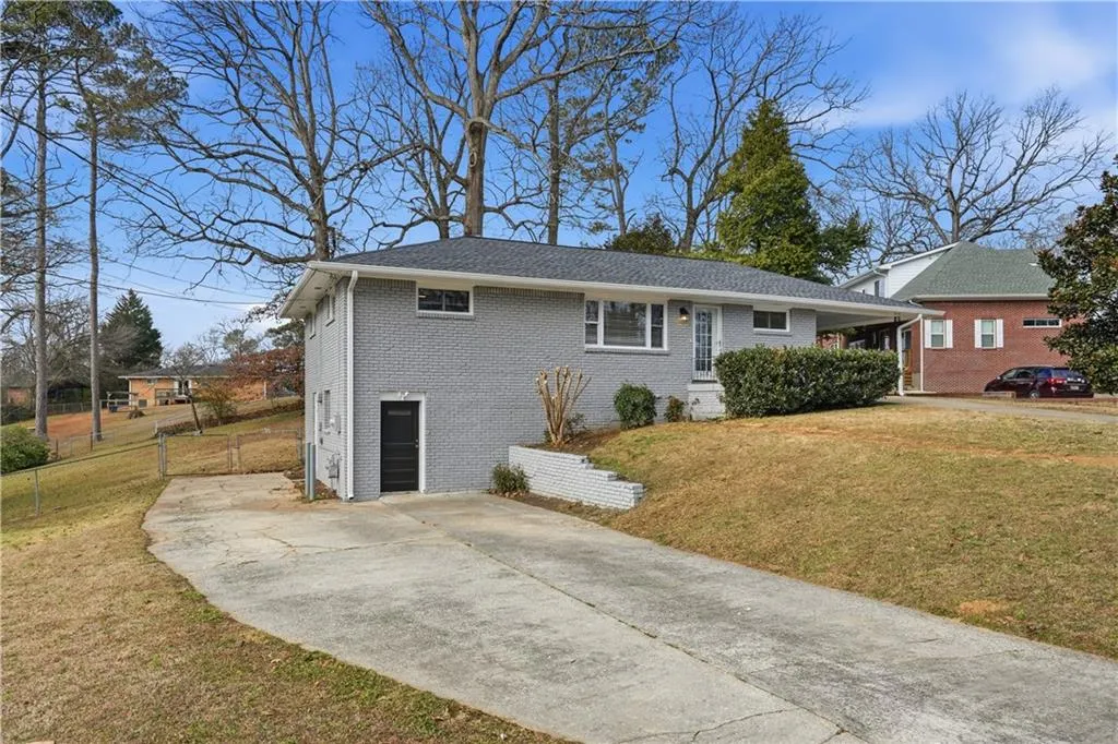 View of front of home featuring a front lawn, brick siding, and concrete driveway