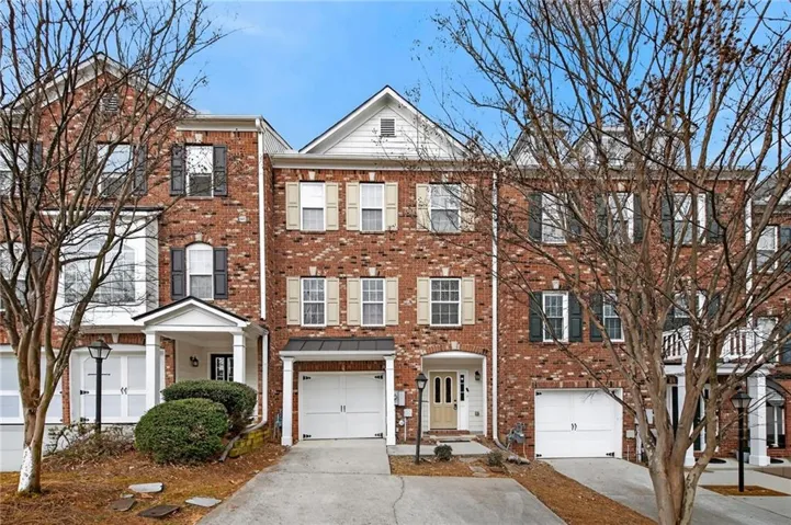 Colonial home featuring brick siding, concrete driveway, and an attached garage