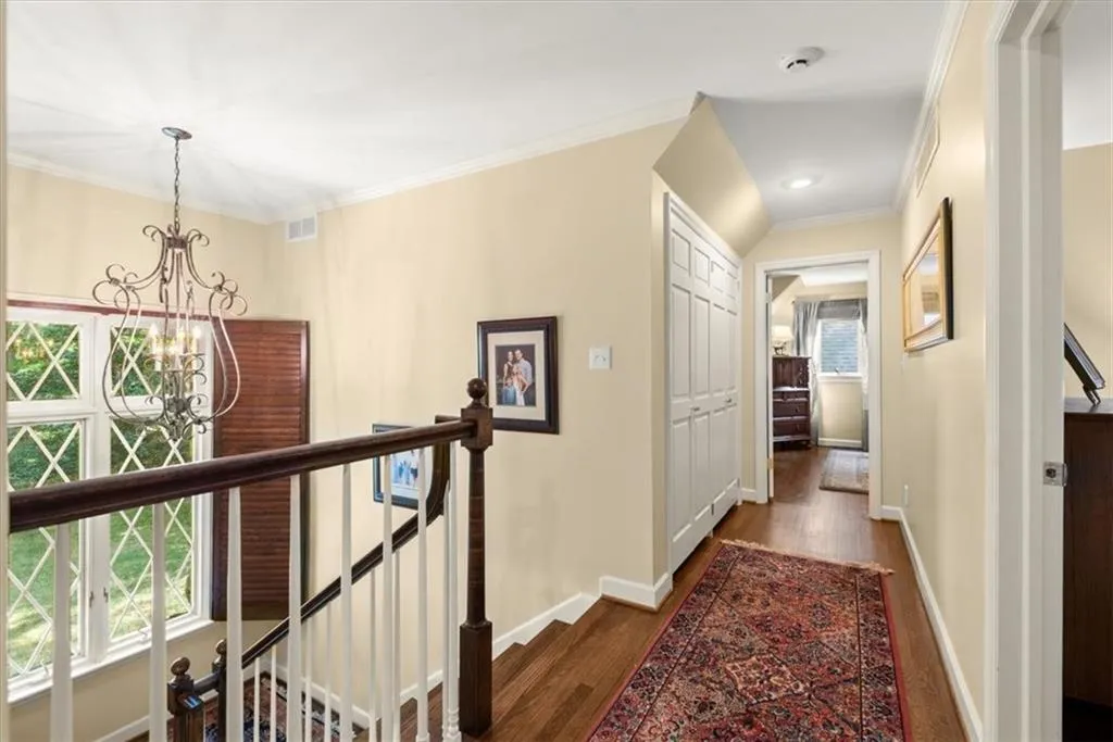 Hall featuring crown molding, a chandelier, and hardwood / wood-style floors