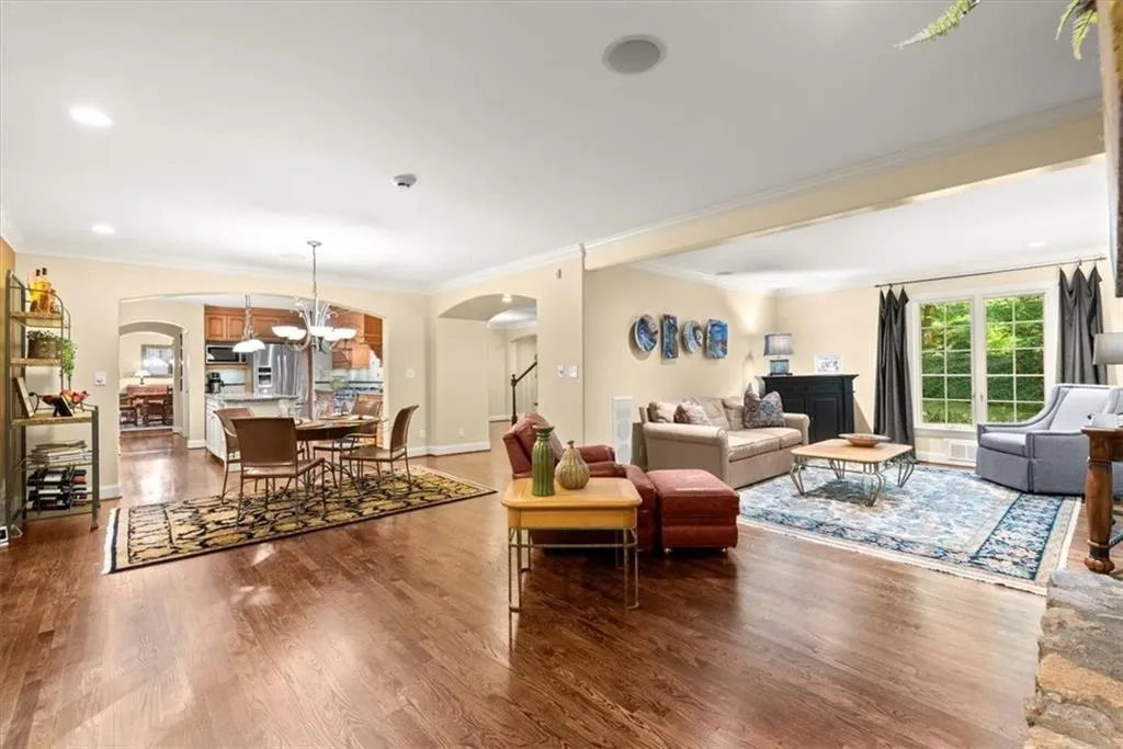 Living room featuring ornamental molding, an inviting chandelier, and hardwood / wood-style floors