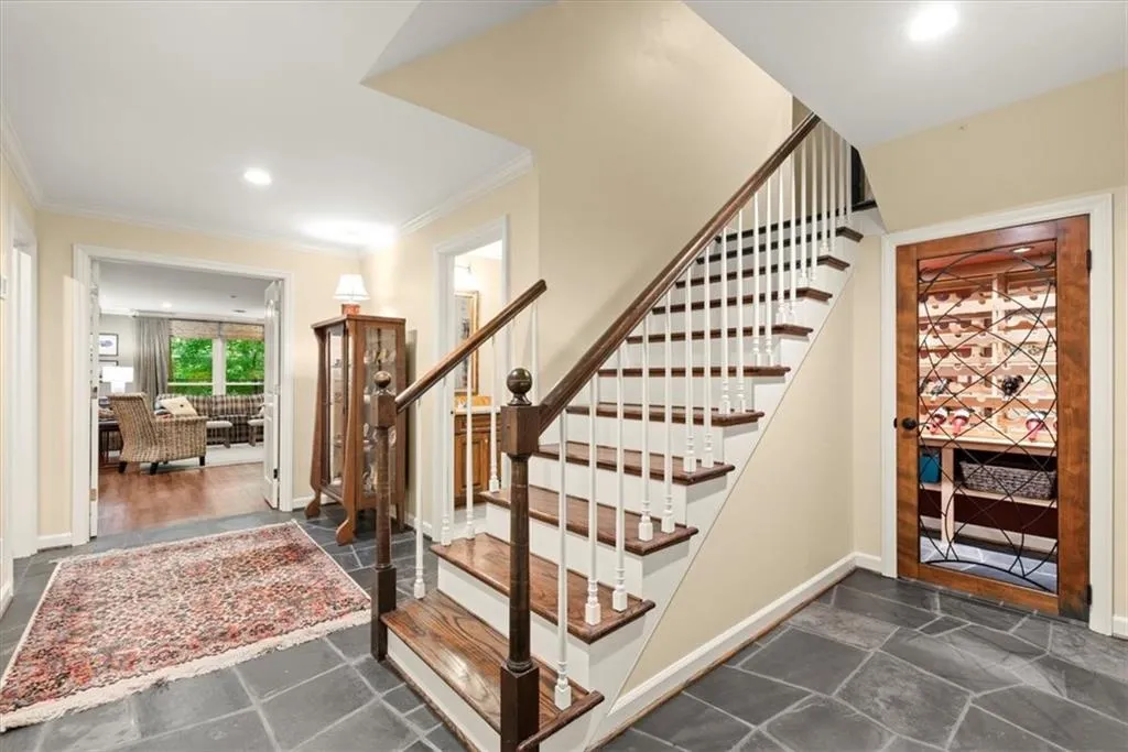 Staircase with dark tile floors and crown molding