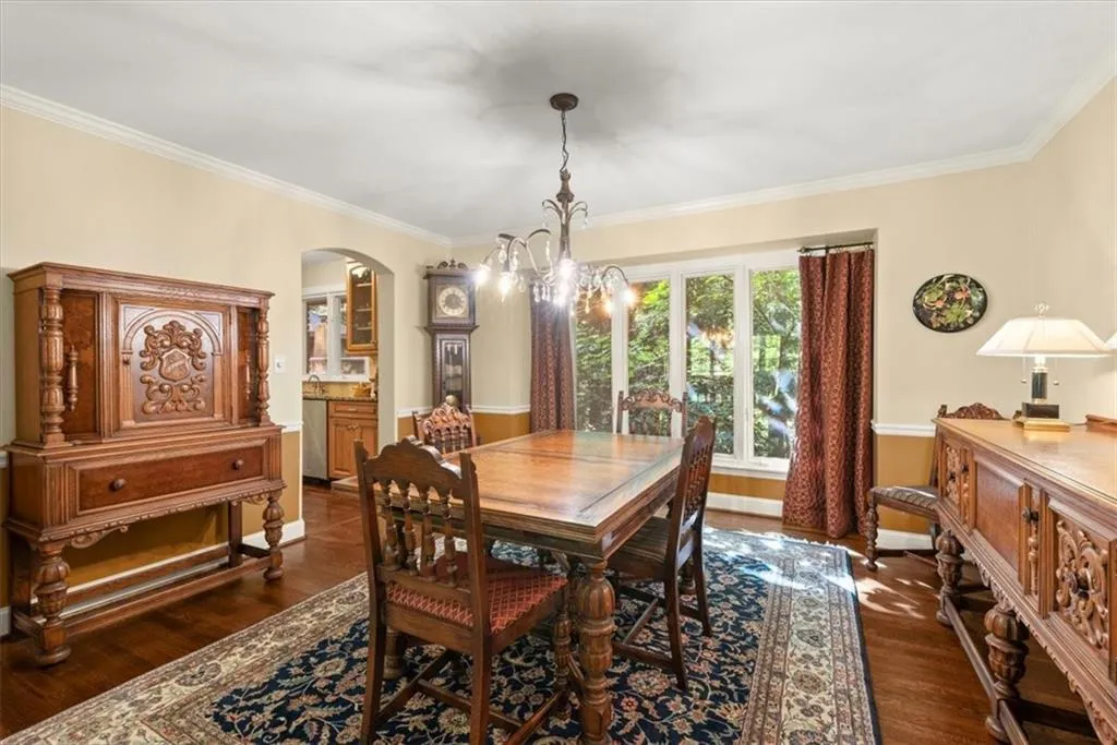 Dining area featuring crown molding, a notable chandelier, and dark hardwood / wood-style flooring