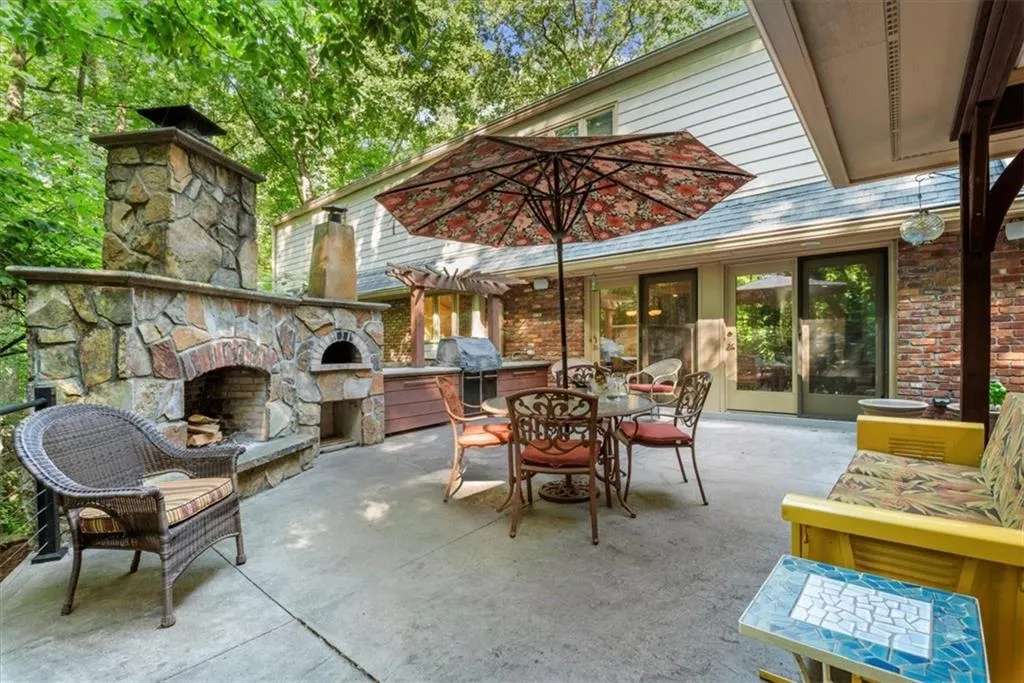 View of patio / terrace featuring grilling area and an outdoor stone fireplace