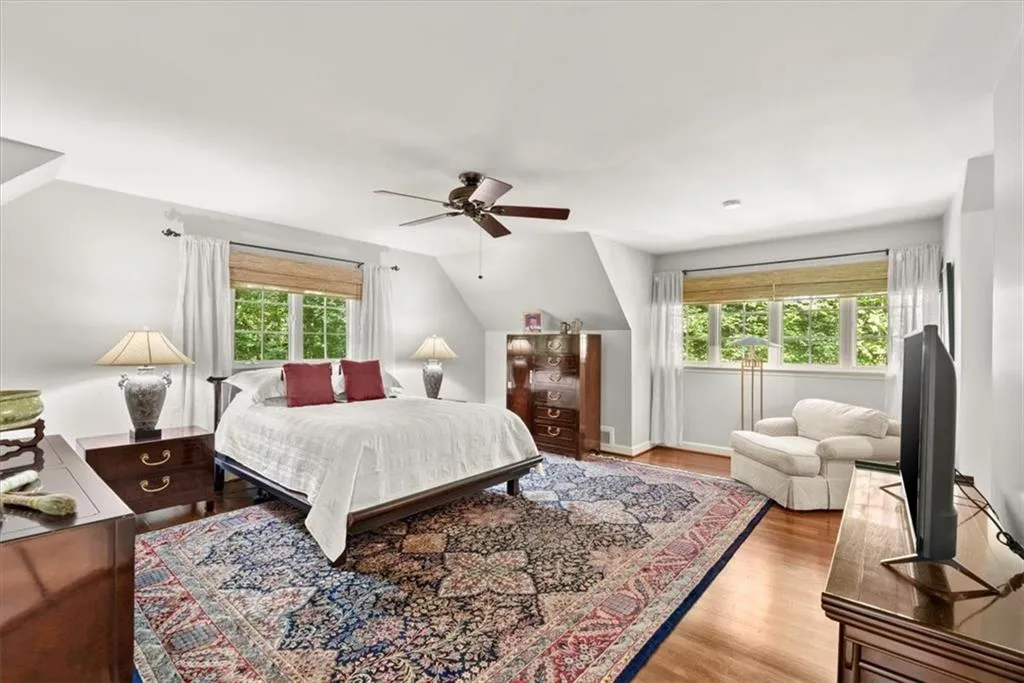 Bedroom featuring ceiling fan, vaulted ceiling, and light wood-type flooring