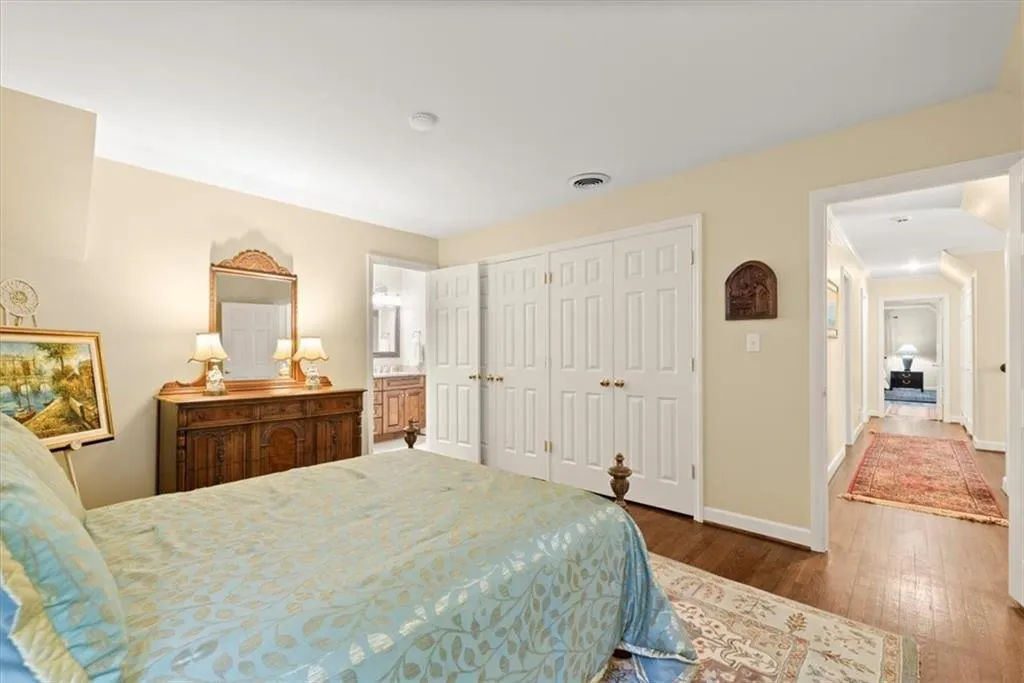 Bedroom with dark hardwood / wood-style floors, a closet, and ensuite bath