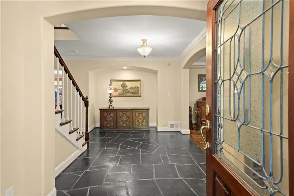 Foyer with dark tile flooring and ornamental molding