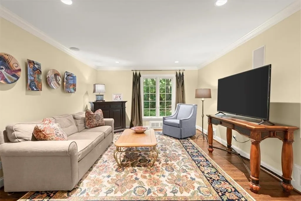 Living room with ornamental molding and wood-type flooring
