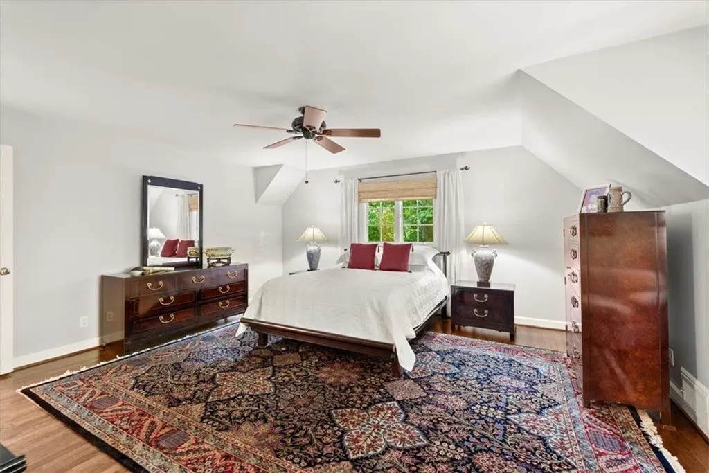 Bedroom featuring ceiling fan, hardwood / wood-style floors, and lofted ceiling
