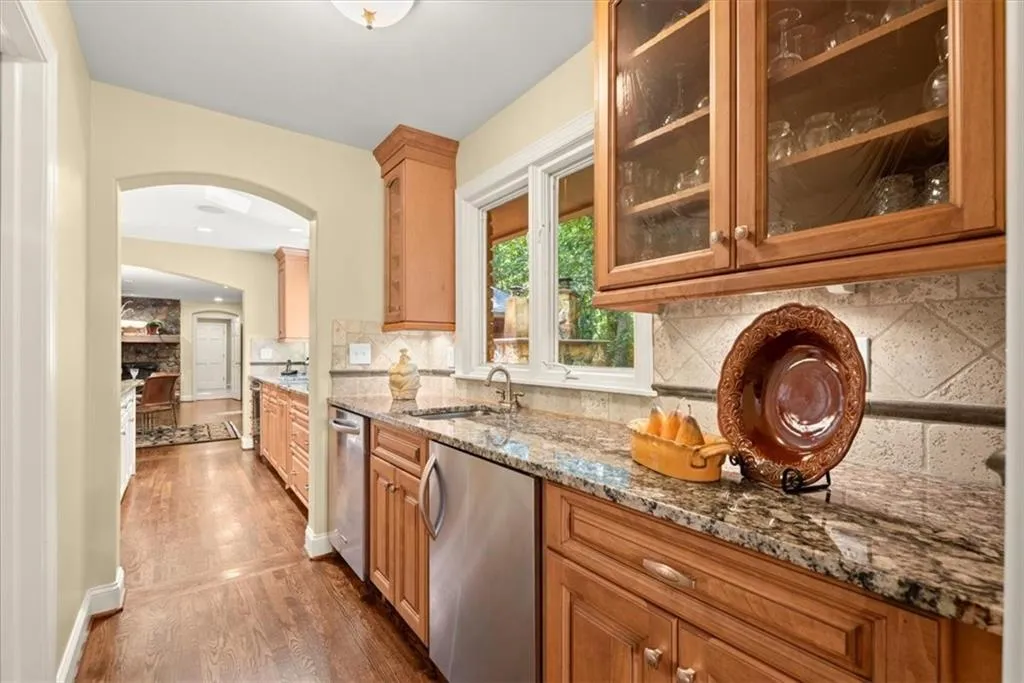 Kitchen with sink, hardwood / wood-style flooring, tasteful backsplash, and dishwasher