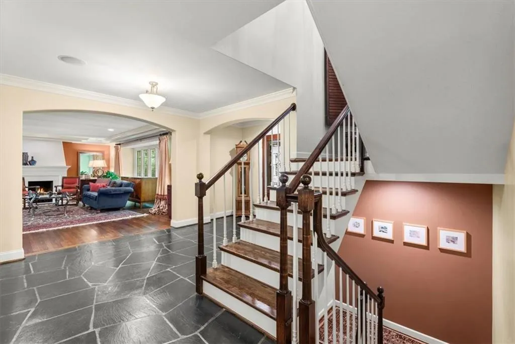 Stairs featuring dark tile floors and crown molding