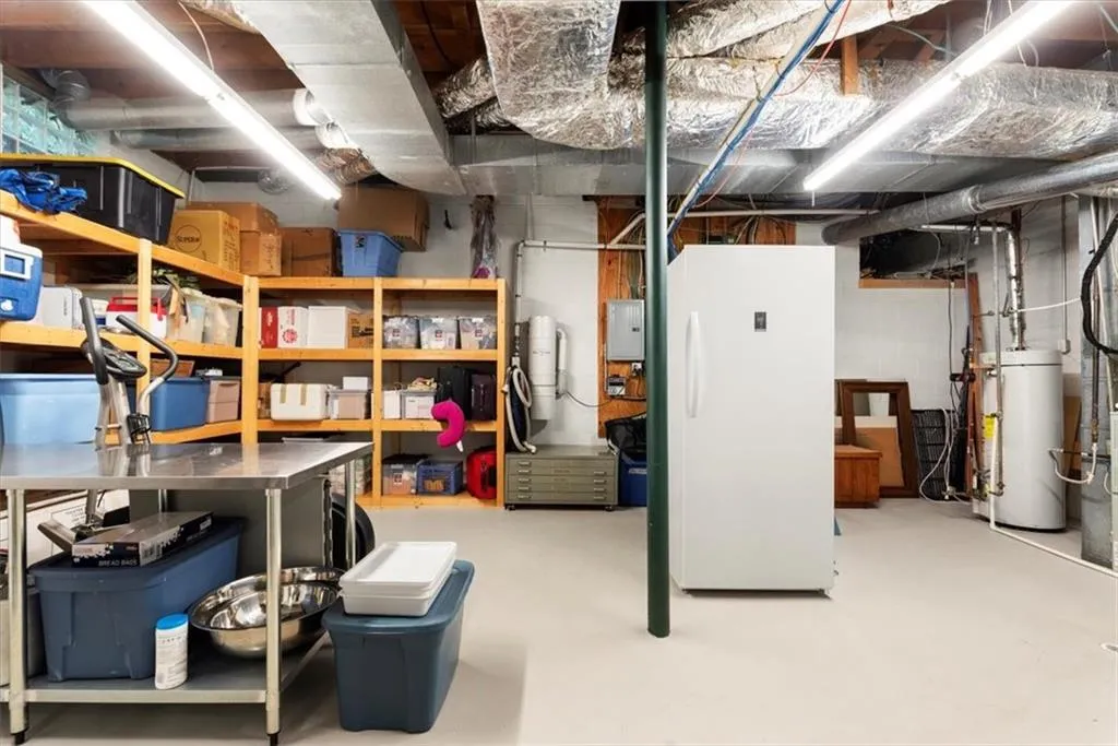 Basement with white refrigerator and gas water heater