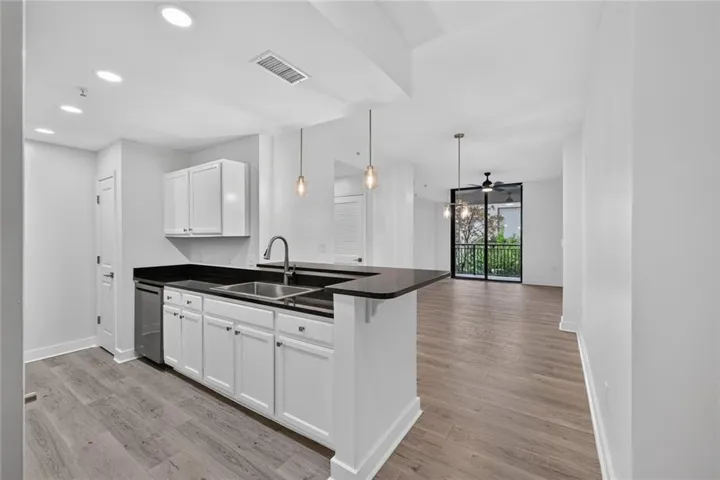 Modern kitchen featuring a peninsula with a dark countertop and stainless steel sink