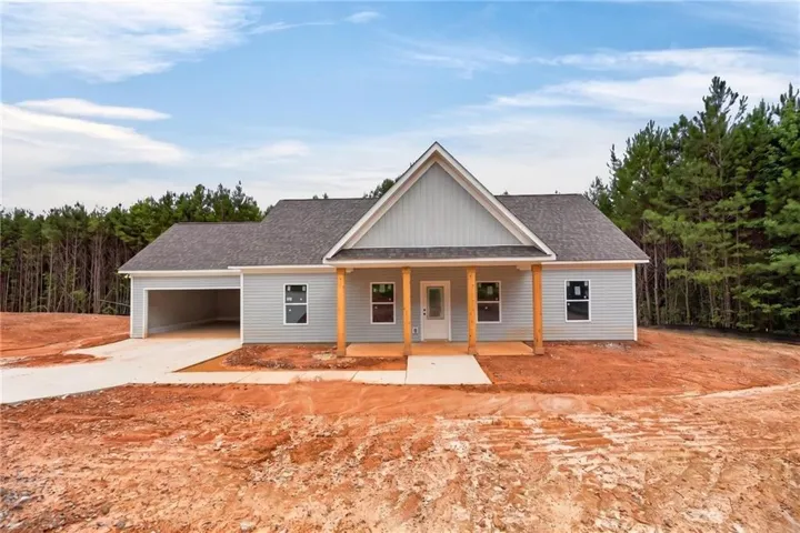Ranch-style residence featuring light blue siding with white trim, a dark shingle roof, and a prominent front gable