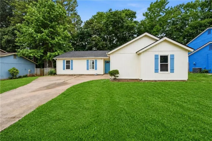Cream-colored siding exterior with blue accent shutters and a matching blue front door