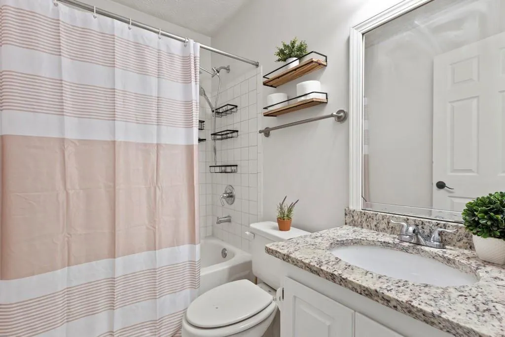 Full bath with shower / bath combo, toilet, and va