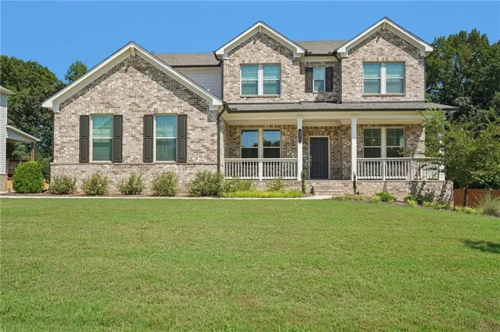 Brick facade with gabled roof lines, covered front porch, and dark louvered shutters