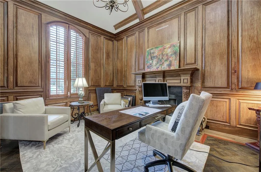 Office area with a decorative wall, a chandelier, wood walls, and ornamental molding