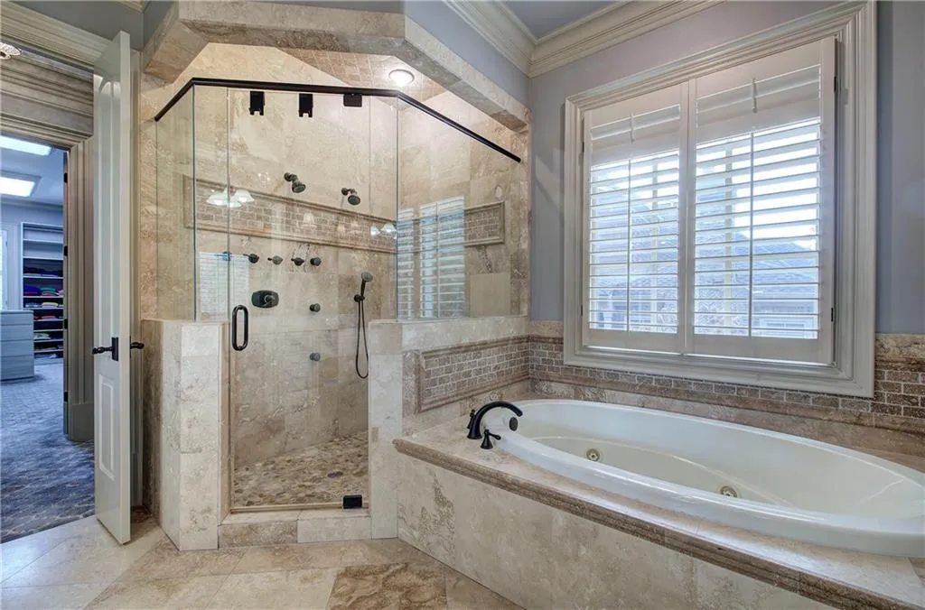 Bathroom with crown molding, a whirlpool tub, and a shower stall