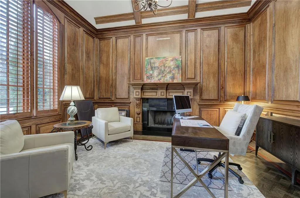 Office space with wooden walls, a premium fireplace, and a decorative wall