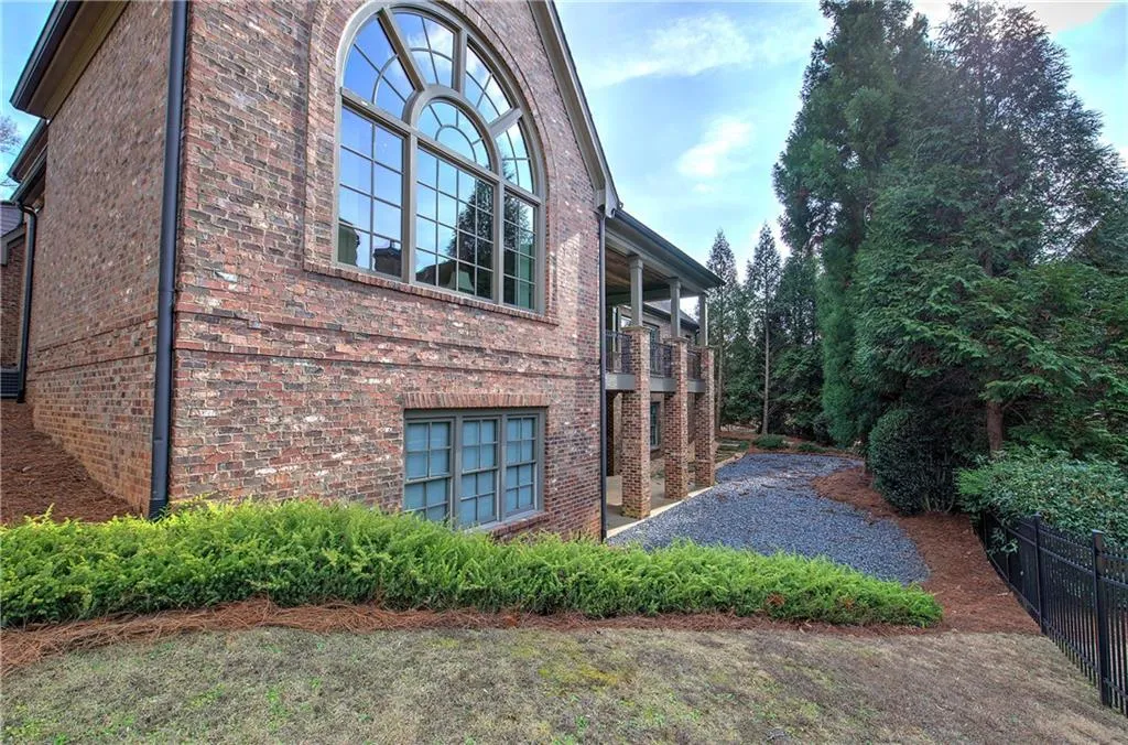 View of property exterior featuring brick siding and a balcony
