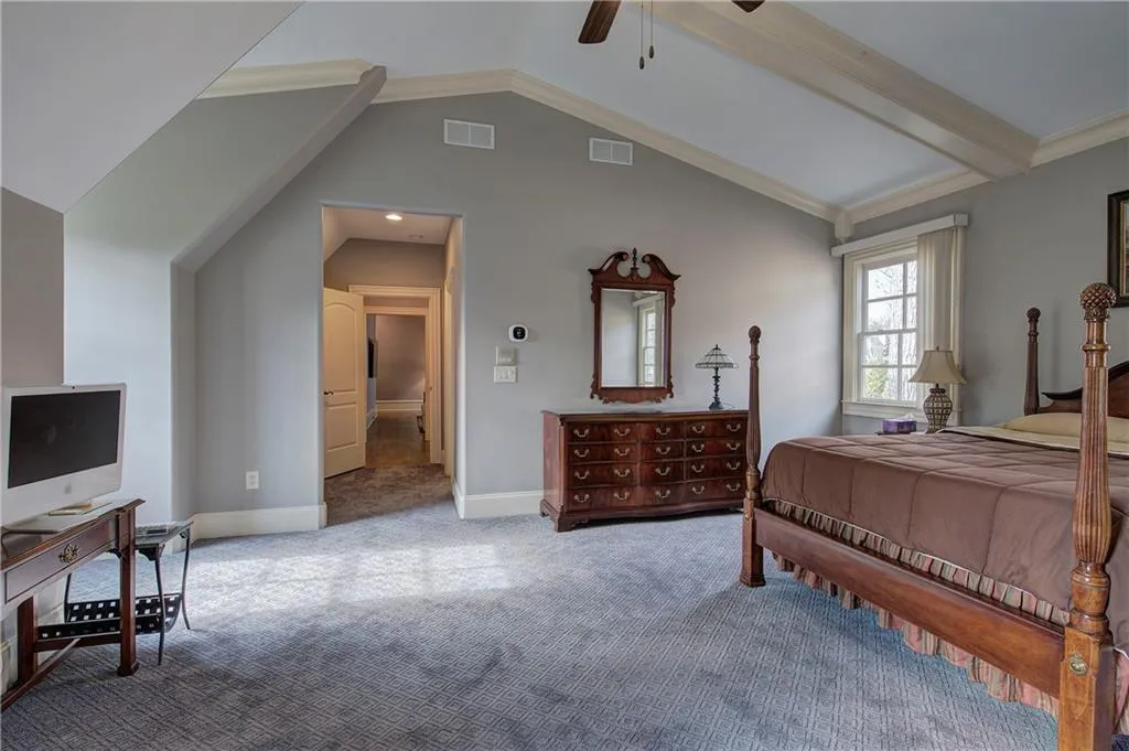 Carpeted bedroom with a desk, a ceiling fan, and ornamental molding