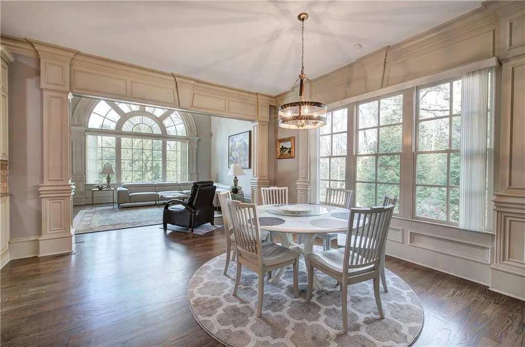 Dining area featuring a decorative wall, dark wood finished floors, crown molding, and a chandelier