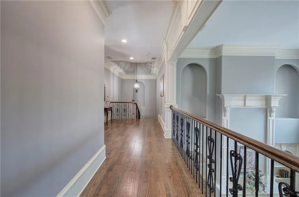 Corridor with wood finished floors, crown molding, an upstairs landing, and recessed lighting