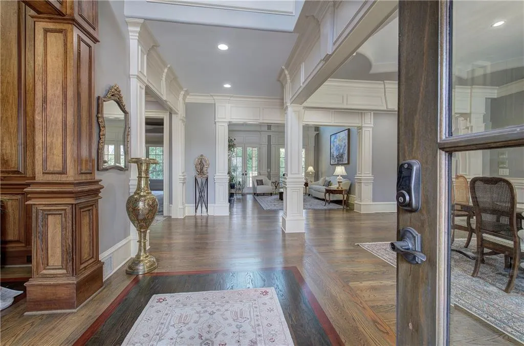 Foyer with decorative columns, dark wood finished floors, recessed lighting, and crown molding