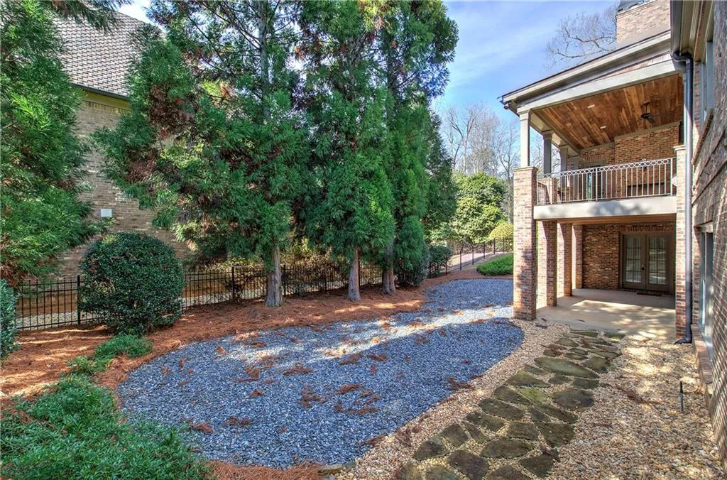 View of yard featuring a patio area, french doors, and a balcony