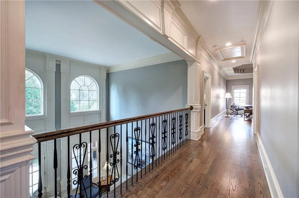 Hall with attic access, crown molding, and dark wood-style floors