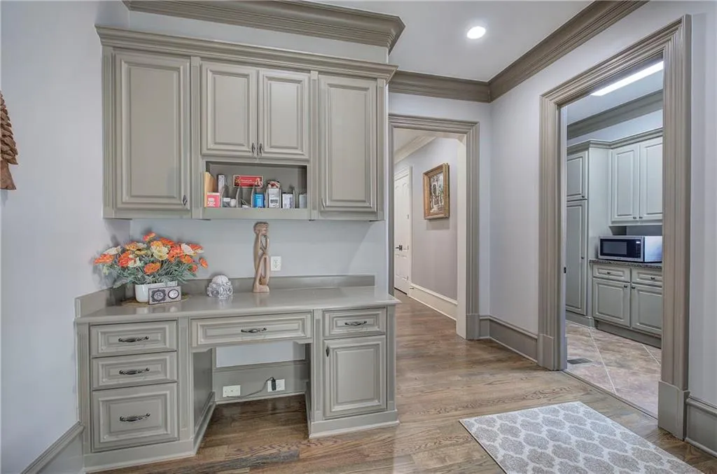 Office space featuring light wood-type flooring, ornamental molding, and built in study area