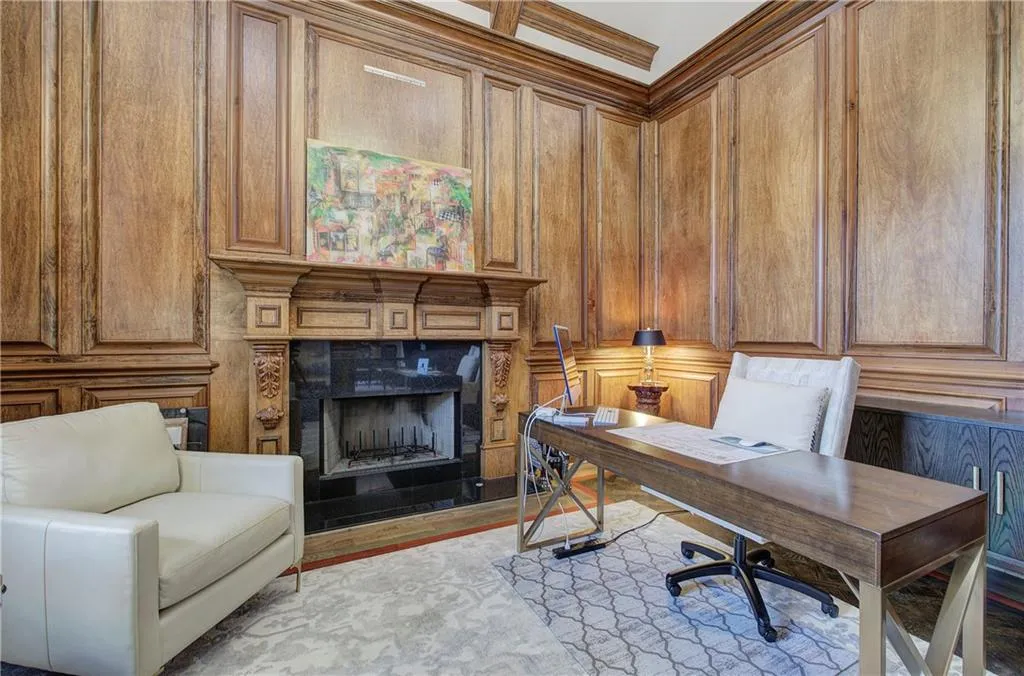 Home office with wood walls, a high end fireplace, and wood finished floors