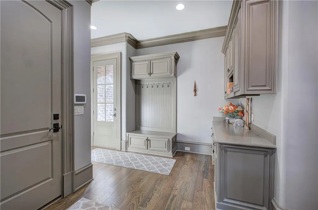 Mudroom with dark wood-type flooring, ornamental molding, and recessed lighting