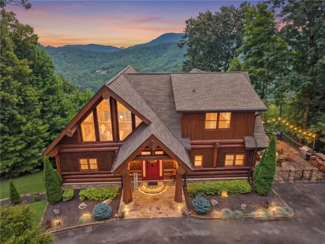 Log-style home featuring a prominent gabled roofline and extensive window arrangements