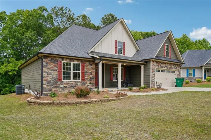 Stone and siding exterior with red window shutters