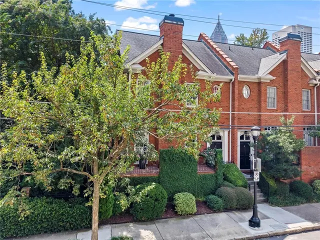 Brick exterior featuring multiple chimneys, gabled rooflines, and arched entryways