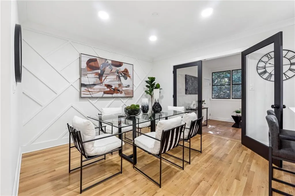 Dining space with french doors, a decorative wall, light wood-style flooring, recessed lighting, and crown molding