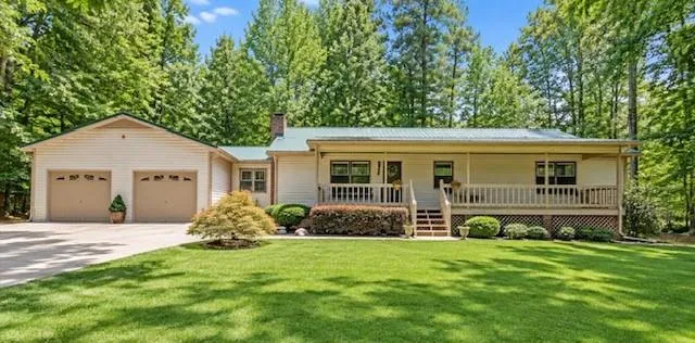 Expansive front lawn with mature trees and established landscaping