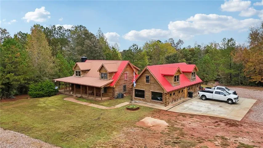 Aerial view of property and surrounding area with a heavily wooded area