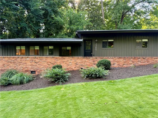 Contemporary exterior featuring board-and-batten siding and a brick facade